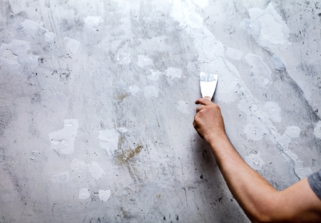 fachowiec szpachluje ścianę